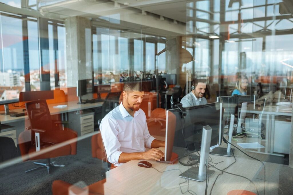 man at desk in office happily working